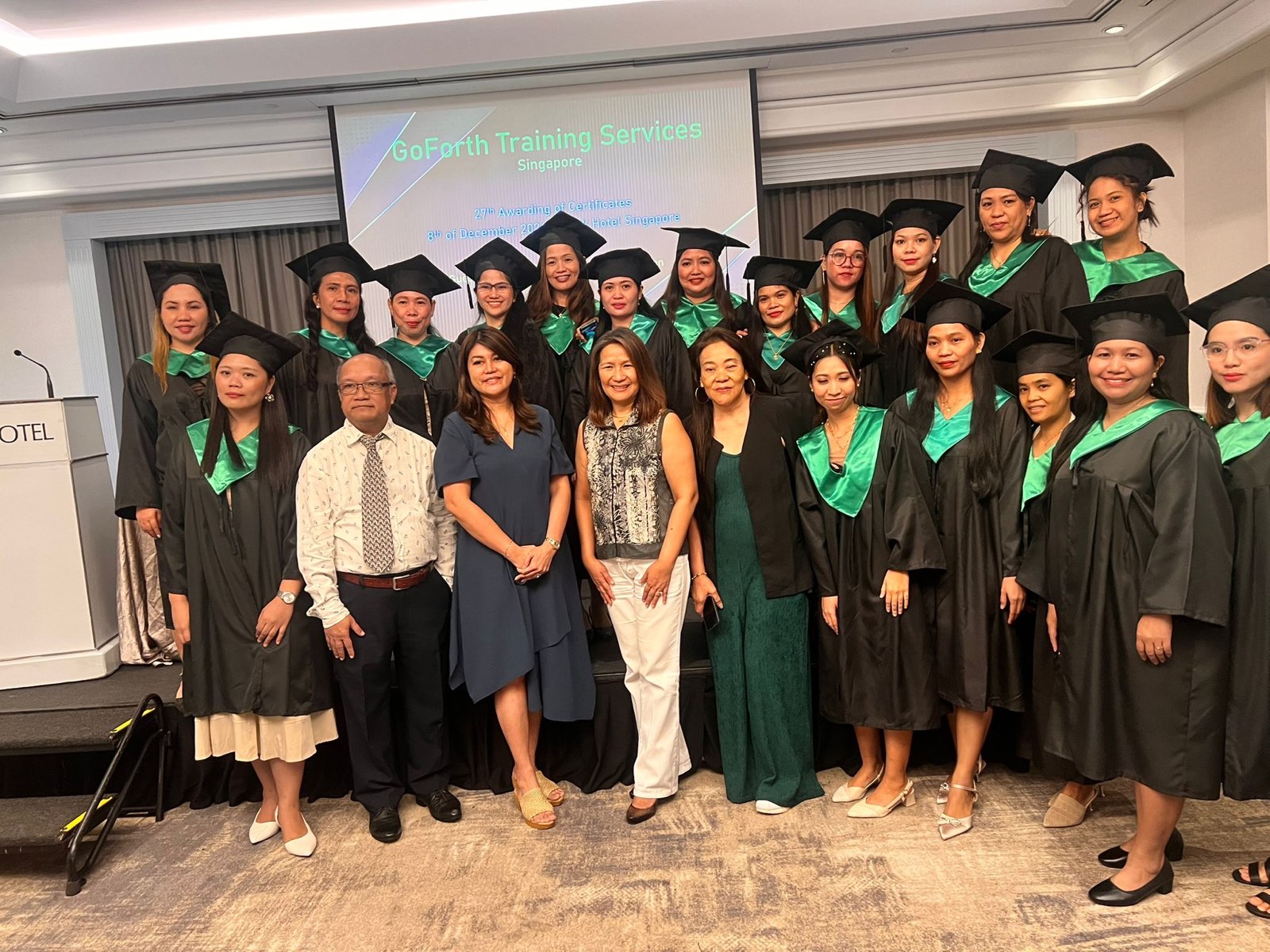 A group of students in graduation robes posing for a photo at the graduation ceremony